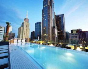 Relaxing outdoor pool with skyline view at the Statler Dallas, Curio Collection by Hilton.