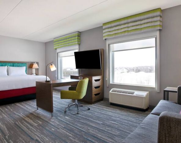 Spacious King suite with 1 king bed,couch, desk area and living room space at the Hampton Inn & Suites Outtawa West