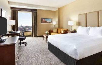King room with 1 king bed, desk,chair and view of downtown at the Hilton Saint John