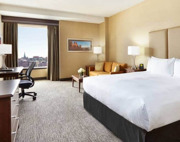 King room with 1 king bed, desk,chair and view of downtown at the Hilton Saint John