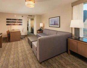 Spacious living room with working station in a king suite at the Embassy Suites by Hilton Chicago Magnificent Mile.