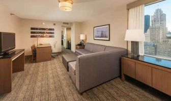 Spacious living room with working station in a king suite at the Embassy Suites by Hilton Chicago Magnificent Mile.