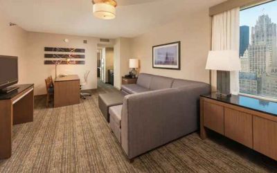 Spacious living room with working station in a king suite at the Embassy Suites by Hilton Chicago Magnificent Mile.