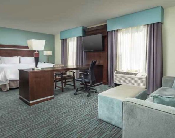 Spacious hotel suite with king size bed and working station at the Hampton Inn & Suites Schererville.