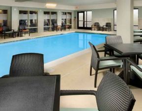 Relaxing indoor pool area with tables and chairs at the Hampton Inn & Suites Schererville.