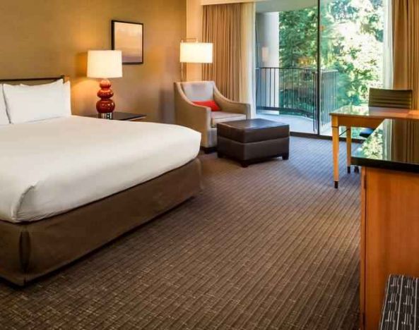 Comfortable king bedroom with balcony at the DoubleTree by Hilton Seattle Airport.