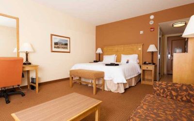 Spacious king suite with sofa and desk at the Hampton Inn & Suites Riverton, WY.