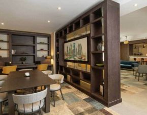 Spacious work lounge area in the lobby with large wooden bookshelves making for cozy partitions.