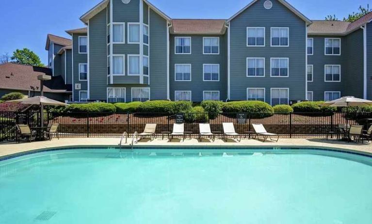 Large outdoor pool with tanning beds and seating at Homewood Suites by Hilton Atlanta-Galleria/Cumberland.
