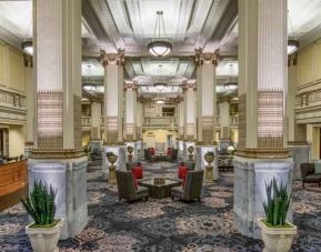 Elegant lobby area with tables and chairs perfect as workspace at the Embassy Suites by Hilton Portland-Downtown.