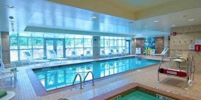 beautiful indoor pool with seating at Hilton Garden Inn Rockville-Gaithersburg.