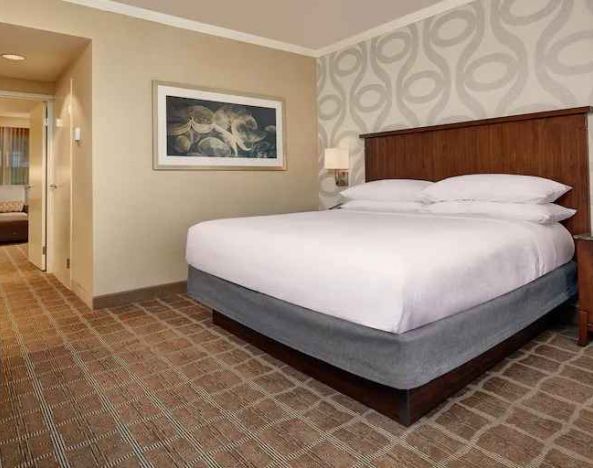 Comfortable king size bed in a hotel suite at the Embassy Suites by Hilton San Diego-La Jolla.