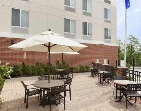 Outdoor patio with tables and chairs perfect as workspace at the Hilton Garden Inn Silver Spring White Oak.