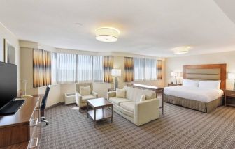 Beautiful king suite with desk, TV screen and sofa at the Hilton Crystal City at Washington Reagan National Airport.