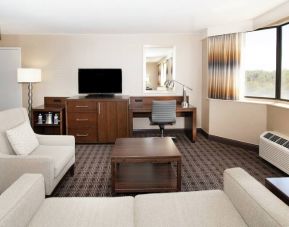 Sofa, TV screen and desk in a king suite at the Hilton Crystal City at Washington Reagan National Airport.