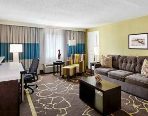 Spacious and comfortable living room with working station at the DoubleTree by Hilton Charlotte-Gateway Village.