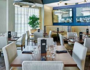 Restaurant area with tables and chairs perfect as workspace at the DoubleTree by Hilton Charlotte-Gateway Village.