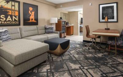 Living room with working station in a king suite at the Embassy Suites by Hilton San Francisco Airport.