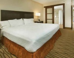 King size bed in a hotel suite at the Embassy Suites by Hilton Miami - International Airport.