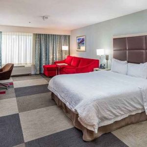 Spacious king room with work area and lounge at Hampton Inn San Francisco Airport.