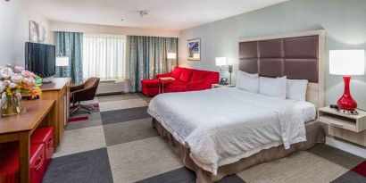 Spacious king room with work area and lounge at Hampton Inn San Francisco Airport.