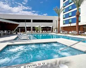 beautiful outdoor pool with seating and sun beds at Hampton Inn & Suites Las Vegas Convention Center.