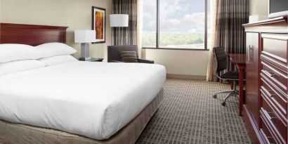 King size bed and desk in a king guestroom at the DoubleTree by Hilton Kansas City - Overland Park.
