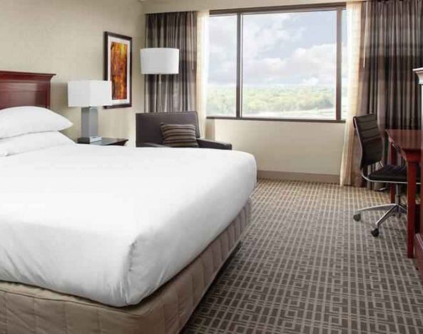 King size bed and desk in a king guestroom at the DoubleTree by Hilton Kansas City - Overland Park.