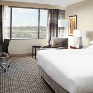 Bright and comfortable king bedroom with window at the DoubleTree by Hilton Kansas City - Overland Park.