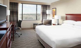 Bright and comfortable king bedroom with window at the DoubleTree by Hilton Kansas City - Overland Park.
