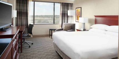 Bright and comfortable king bedroom with window at the DoubleTree by Hilton Kansas City - Overland Park.