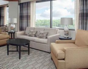 Living area with working station in a hotel suite at the DoubleTree by Hilton Kansas City - Overland Park.