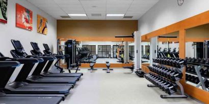 Fitness center with treadmills and weights at the DoubleTree by Hilton Kansas City - Overland Park.
