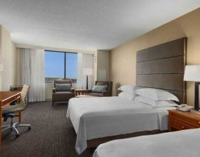Bright double queen room with window and desk at the Hilton Salt Lake City Center.