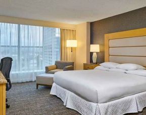 comfortable king-sized bedroom with work space and lounge area at Hilton Los Angeles North/Glendale & Executive Meeting Ctr.
