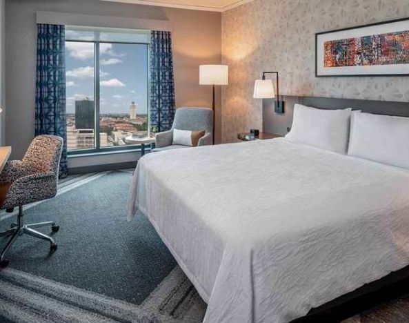 comfortable king bedroom with city views and natural light at Hilton Garden Inn Austin University.