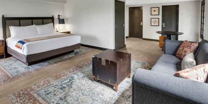 Large guestroom with king size bed and working station at the Estancia del Norte San Antonio, Tapestry Collection.