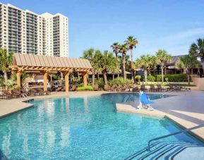 stunning outdoor pool with sun beds and outdoor seating at Kingston Plantation Condos.