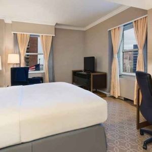 Delux king room with TV, work desk, and natural light at Hilton Milwaukee City Center.