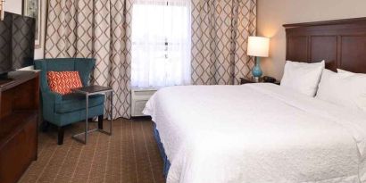 Comfortable king room with TV and work area at Hampton Inn & Suites Pueblo-Southgate.