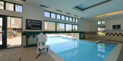 Indoor pool with seating and accessible to otherwise-abled guests at Hampton Inn & Suites Pueblo-Southgate.