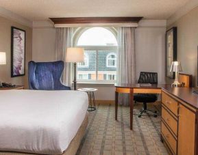 King guestroom with TV screen and desk at the Hilton Wilmington-Christiana.