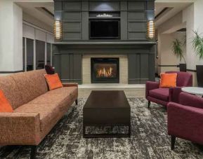 Comfortable workspace by the fireplace in a hotel lobby at the Hilton Garden Inn Blacksburg University.
