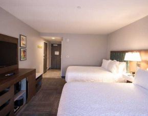 Double queen bedroom with TV screen at the Hampton Inn & Suites North Attleboro.