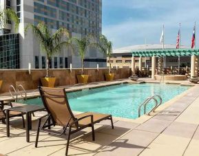 beautiful outdoor pool with sun beds and seating area at Embassy Suites by Hilton Houston Downtown.