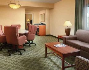 Spacious living room with working station in a hotel suite at the Embassy Suites by Hilton Charleston Airport Convention Center.