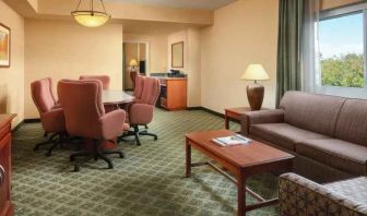 Spacious living room with working station in a hotel suite at the Embassy Suites by Hilton Charleston Airport Convention Center.