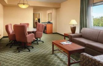 Spacious living room with working station in a hotel suite at the Embassy Suites by Hilton Charleston Airport Convention Center.