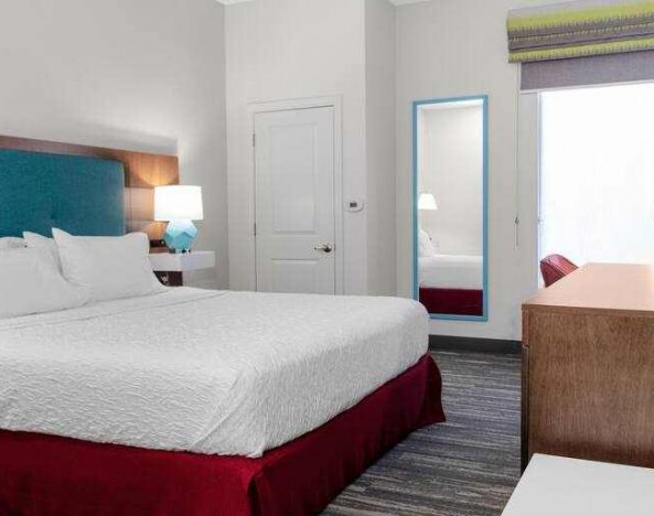 King bedroom with TV screen and window at the Hampton Inn Concord Bow.