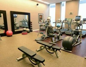 Fully equipped fitness center with mirrors at the Hilton Columbus Downtown.